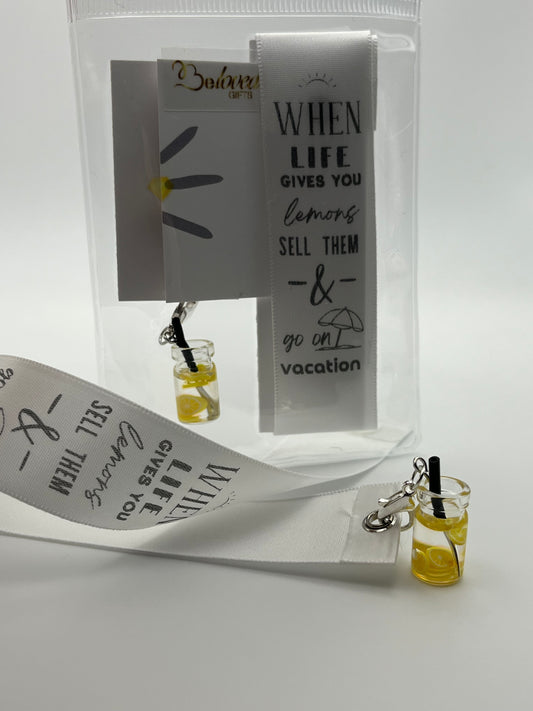 LIFE HUMOUR – “When life gives you lemons, sell them & go on vacation”- White Satin Reusable Adhesive Bookmark with a Charm (Lemonade Cup)
