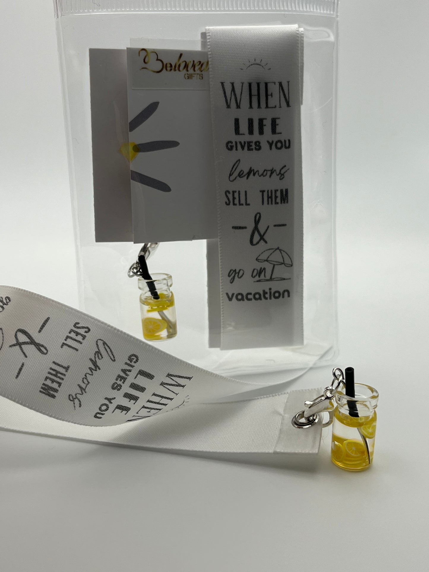 LIFE HUMOUR – “When life gives you lemons, sell them & go on vacation”- White Satin Reusable Adhesive Book-It™ Bookmark with a Charm (Lemonade Cup)