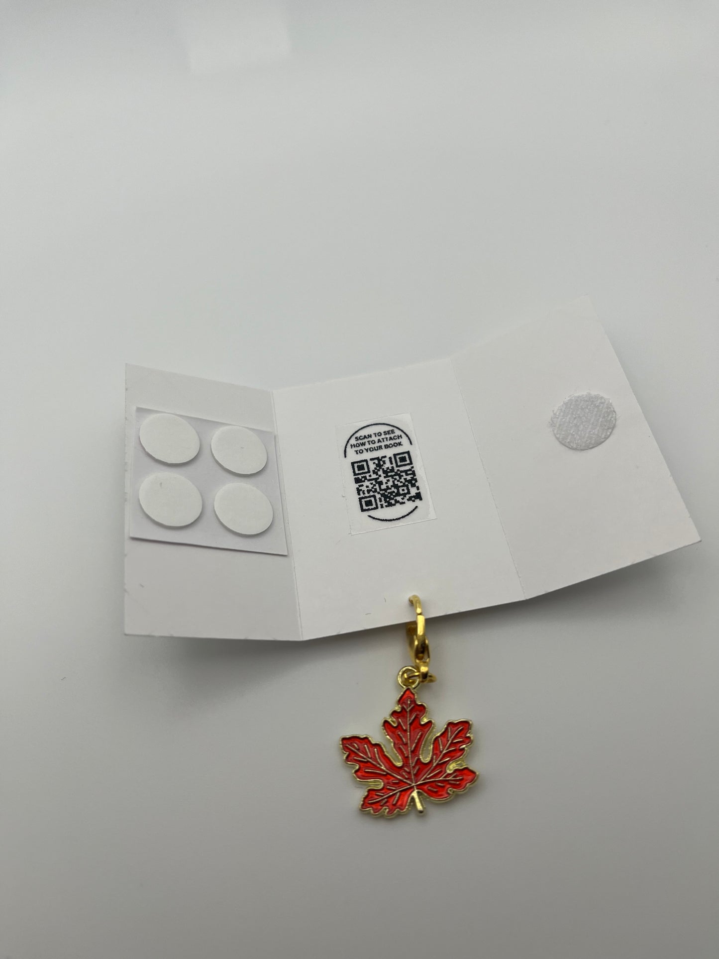 “CANADA, eh?” – Red Satin Reusable Adhesive Bookmark with a Charm (Canadian Maple Leaf) in Gift Box