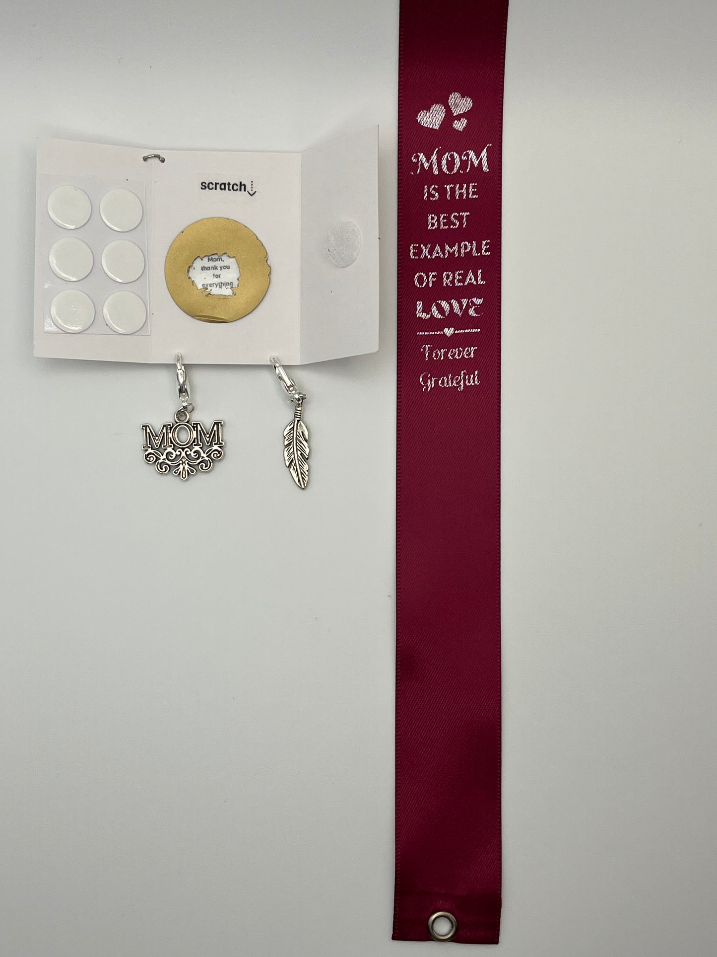 FOR MOM - “Mom is the best example of real love - forever grateful” – Burgundy Satin Reusable Adhesive Book-It™ Bookmark with Two Charms (M-O-M, Feather) in Gift Box + Hidden Scratch Gift Message