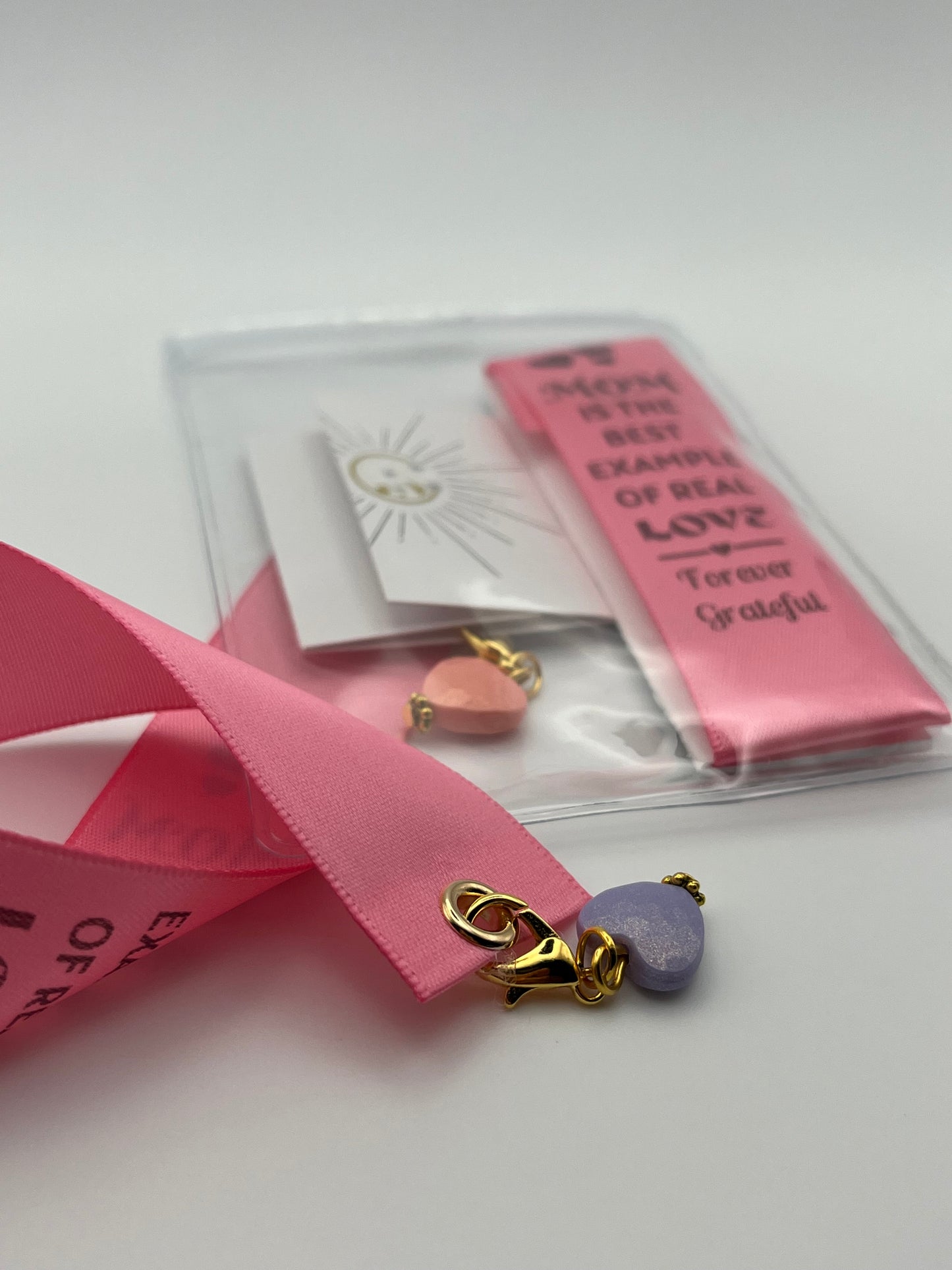 MOTHER’S DAY – “Mom is the best example of real love - forever grateful”- Pink Satin Reusable Adhesive Book-It™ Bookmark with a Charm (Coloured Heart Bead)