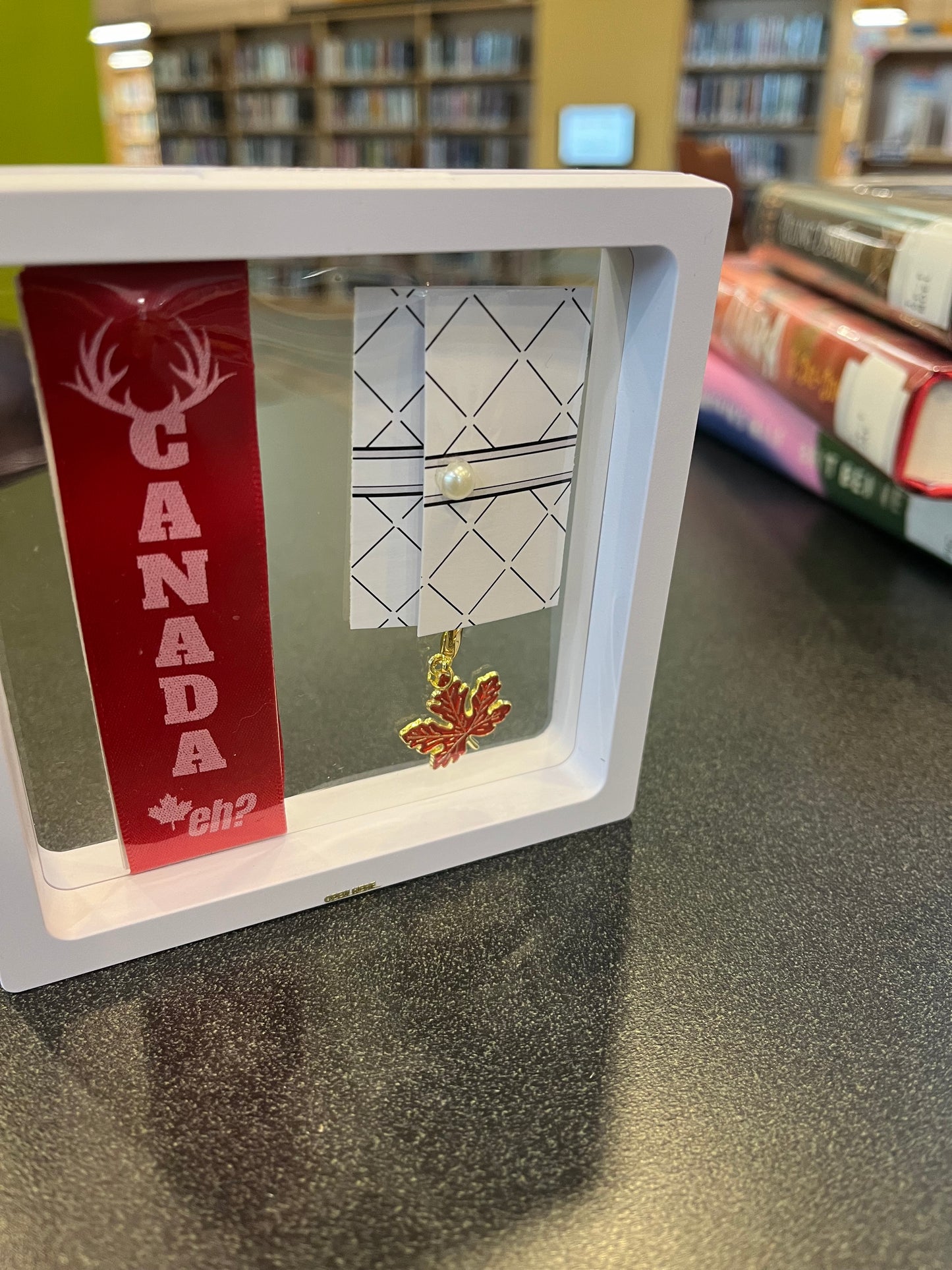 “CANADA, eh?” – Red Satin Reusable Adhesive Bookmark with a Charm (Canadian Maple Leaf) in Gift Box